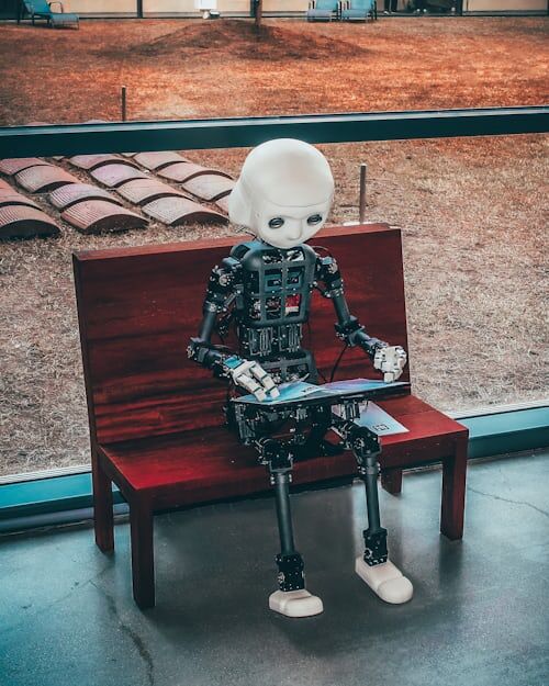 Bild eines Roboters, der auf einer Bank sitzt und einen Computer benutzt, wie künstliche Intelligenz, die sich verwandelt Instagram
