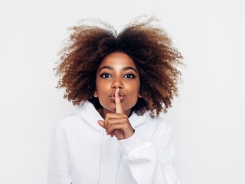 Beautiful afro woman showing to be quiet | Path Social Mujer haciendo el gesto de callar para representar el modo Vanish en Instagram