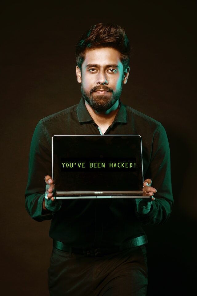 pexels-saksham-choudhary-2036656 | Path Social Hombre sosteniendo un portátil con las palabras "¡Has sido hackeado!"