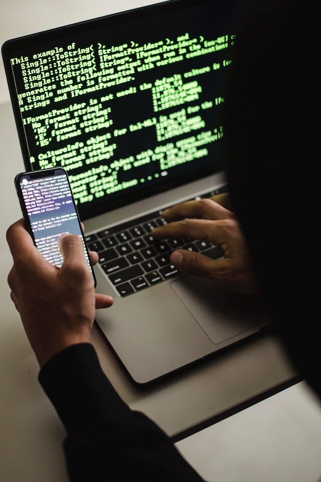 pexels-sora-shimazaki-5935791 | Path Social هاكر على كمبيوتر محمول باستخدام هاتف محمول.