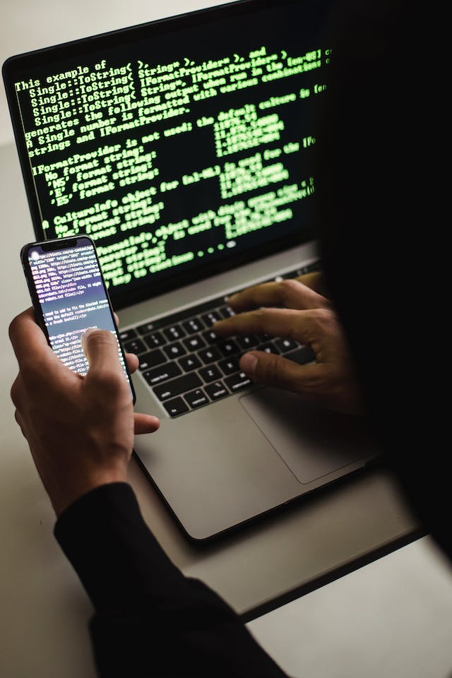 pexels-sora-shimazaki-5935791 | Path Social Una persona con uno smartphone che scrive su un computer portatile.