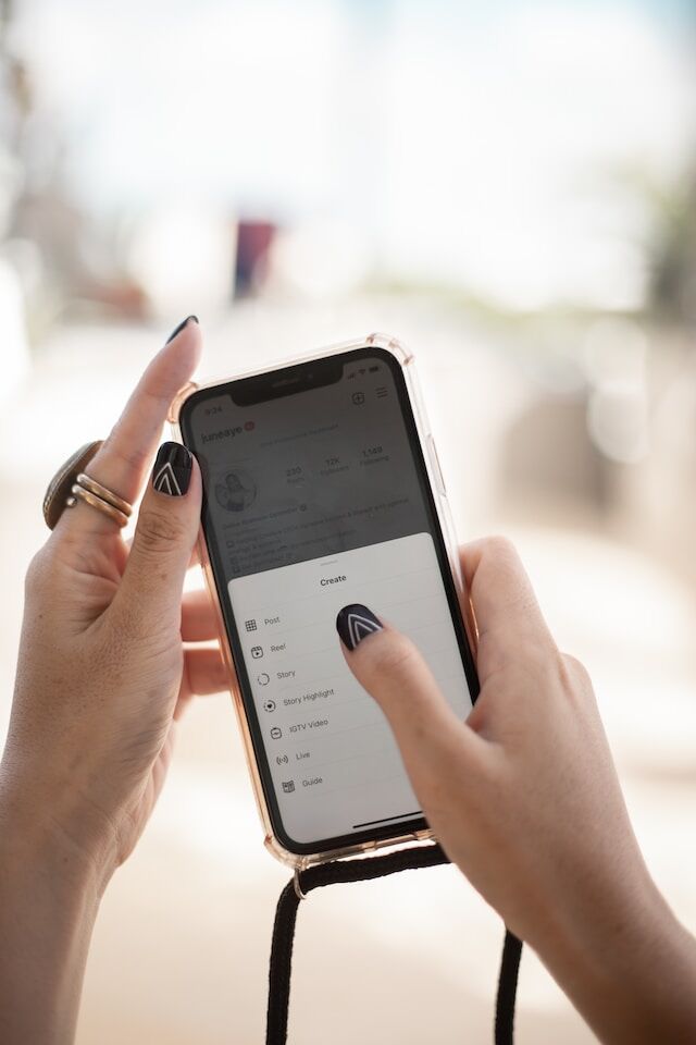 june-aye-ddXvOGrWGSw-unsplash | Path Social O femeie ține în mână un telefon și dă clic pe opțiunea Instagram .