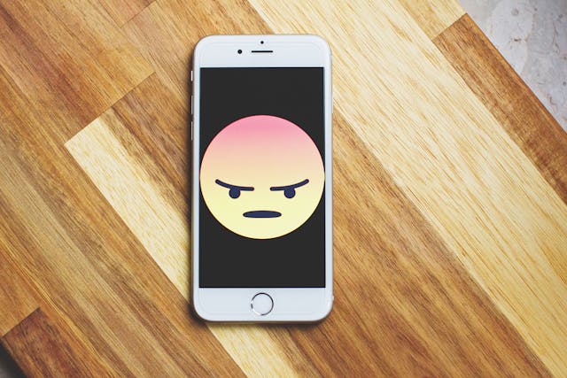 pexels-freestocks-987585 | Path Social Un iPhone argintiu cu un emoji furios pe ecran.