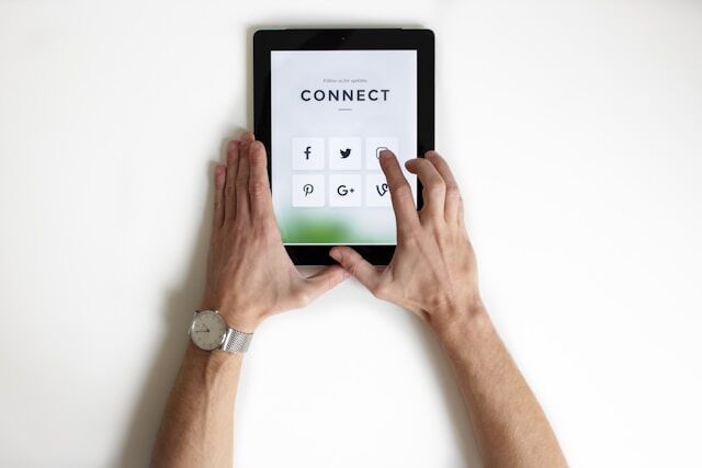 nordwood-themes-yyMJNPgQ-X8-unsplash | Path Social A person tapping on the Instagram icon on an iPad displaying different social media platforms under the word “Connect.”