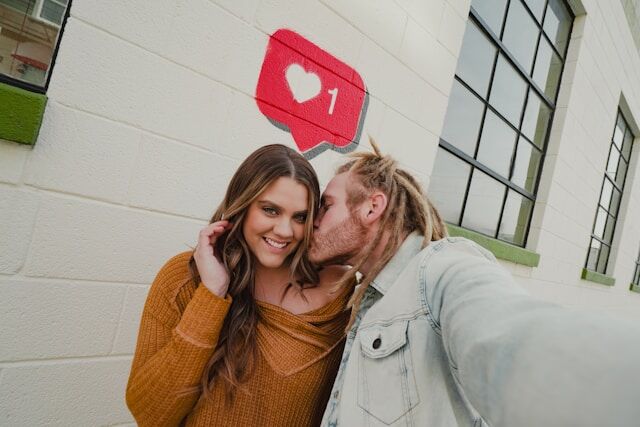 karsten-winegeart-ej1WGkMZ9zY-unsplash | Path Social The pink Instagram “like” icon above a couple taking a kissing selfie.