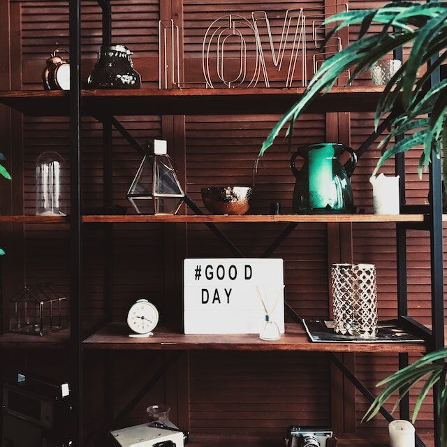 A card on a shelf with “hashtag GOOD DAY” printed on it.