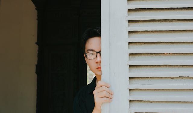 Man hiding behind door.