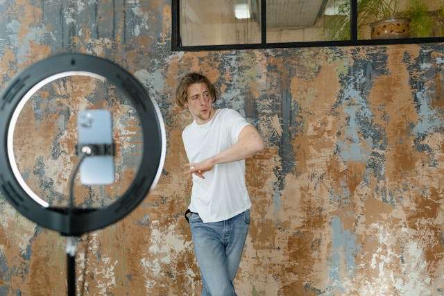 A man dancing in front of his smartphone and tripod to film an Instagram Reel.