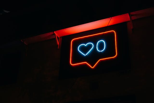 A blue and orange neon sign showing zero Instagram likes within a bubble border.