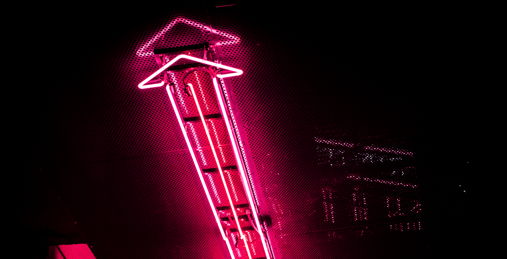 Red neon arrow pointing up to demonstrate growth with the help of an Instagram growth service.