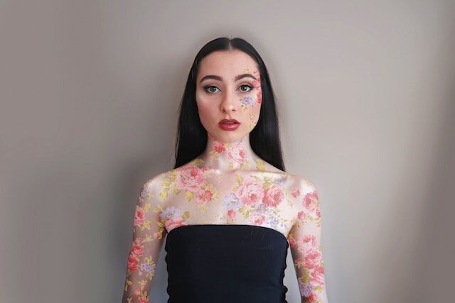 Femeie Instagram influencer cu vopsea de corp florală.