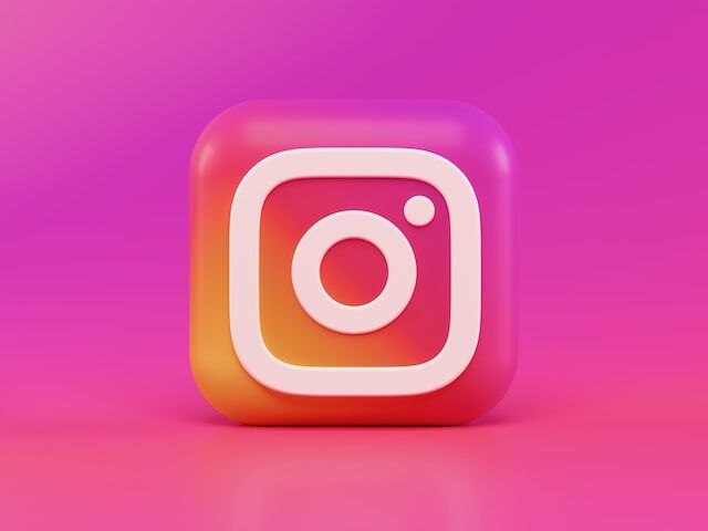 Instagram的相機圖示在粉紅色和橙色立方體上以白色勾勒。