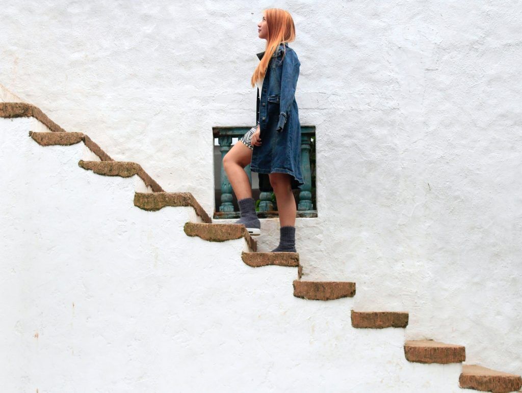 Femme montant des escaliers en béton. 