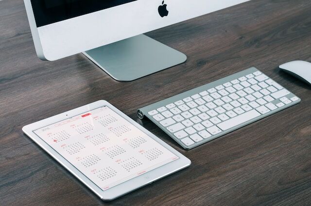 Ordenador y tableta con calendario que indica un calendario de publicaciones para la participación en Instagram.