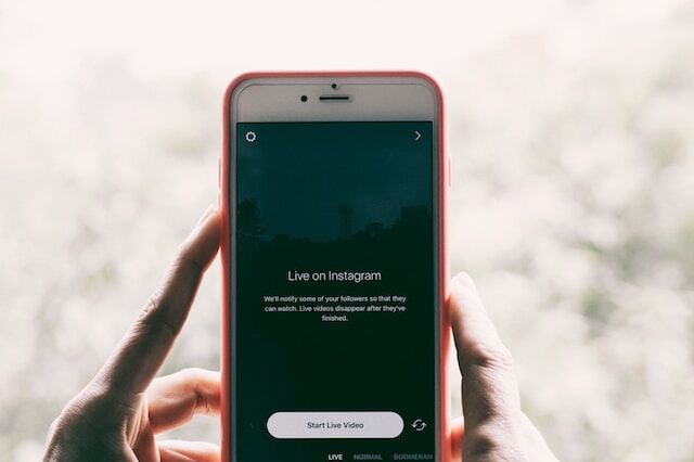 Una persona con un iPhone en la mano en directo en Instagram.