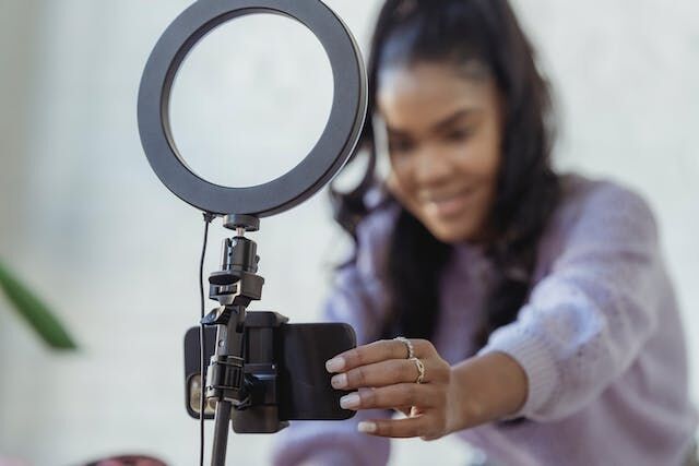 مؤثرة على موقع Instagram تقوم بضبط مصباح خاتمها للاستعداد لتسجيل مقطع فيديو.