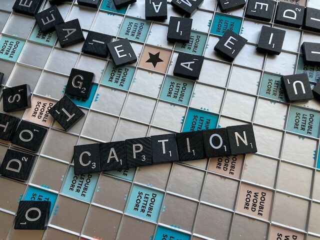 Le tessere dello Scarabeo sul gioco da tavolo che compongono la parola "CAPTION".